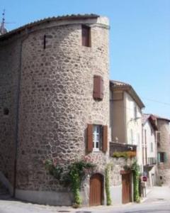 ein großes Steingebäude mit einem Fenster und einer Tür in der Unterkunft Appartement cosy et lumineux dans village medieval in Boulieu-lès-Annonay