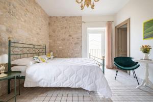 a bedroom with a bed and a green chair at Villa Santa Margherita in Chiaramonte Gulfi