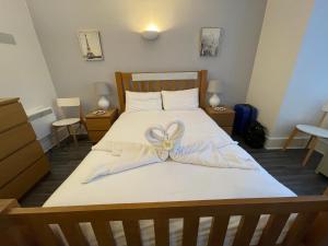 a bedroom with a bed with a bow on it at Bournemouth Hot Tub & Sauna Holiday Let in Bournemouth