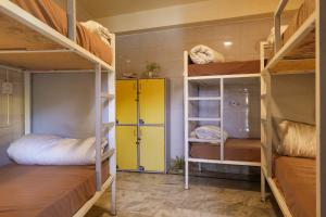 a room with three bunk beds and a yellow door at Shalom Backpackers Rishikesh in Rishīkesh