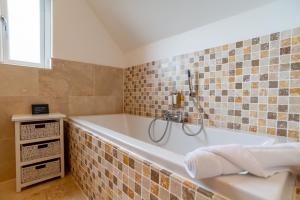 a bathroom with a bath tub with towels on it at Trewhiddle Retreat V17 by Together Travel - Luxury 4-Bedroom Villa in St Austell +36 photos