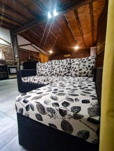 1 dormitorio con 1 cama con edredón blanco y negro en cabaña la olivia en Lunlunta