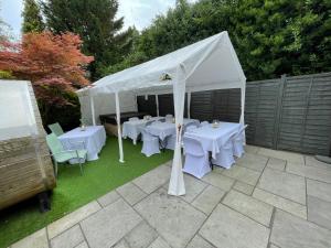 a white tent with tables and chairs in a yard at Bournemouth Hot Tub & Sauna Holiday Let in Bournemouth