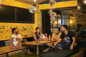 a group of people sitting at a table in a restaurant at Shalom Backpackers Rishikesh in Rishīkesh