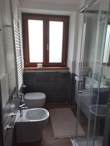 een badkamer met een toilet, een wastafel en een douche bij La coccinella in Oulx