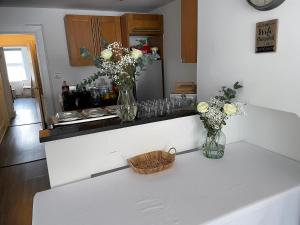 a kitchen counter with two vases with flowers on it at Bournemouth Hot Tub & Sauna Holiday Let in Bournemouth