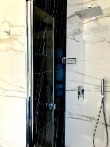 eine Dusche im Bad mit schwarzem und weißem Marmor in der Unterkunft Les Suites di Adi Luxury Apt in Bari