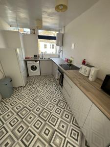 a small kitchen with a sink and a stove at Entire 3 Bedroom Apartment in Felixstowe in Felixstowe