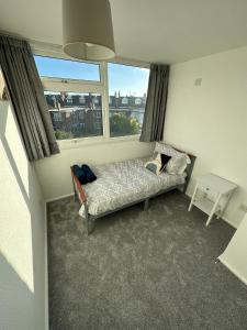 a small room with a bed and a window at Entire 3 Bedroom Apartment in Felixstowe in Felixstowe