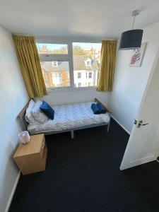 a small bedroom with a bed and a window at Entire 3 Bedroom Apartment in Felixstowe in Felixstowe