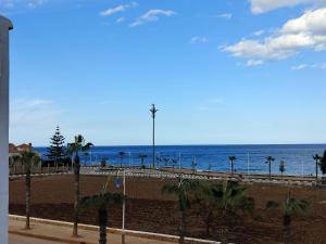 a view of the beach with palm trees and the ocean at Oued laou beach in Oued Laou