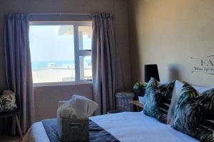 a bedroom with a bed with a view of the beach at Dolphin View 20 @ LongBeach in Langstrand