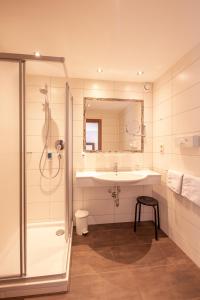 La salle de bains est pourvue d'un lavabo et d'une douche. dans l'établissement Patteriol Apart-Hotel-Garni, à Sankt Anton am Arlberg