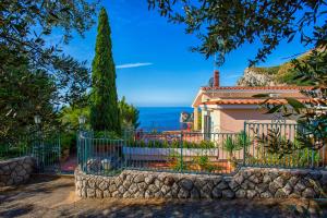 a house with a fence and a view of the ocean at Christa Guest House in Massa Lubrense