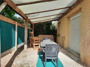 een patio met een tafel en stoelen onder een pergola bij Maison cosy 3 chambres à la campagne in LʼAbergement-Sainte-Colombe
