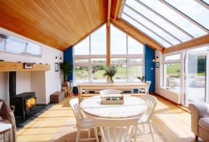 a conservatory with a table and chairs and a fireplace at Home near Port Isaac sleeps 10 in Port Isaac
