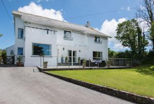 a large white house with a large yard at Home near Port Isaac sleeps 10 in Port Isaac