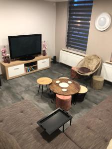 a living room with a television and a table and chairs at Enjoyvilla@sea in Ostend