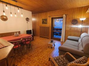 een woonkamer met een bank en een tafel bij La Finestra sui Monti - Alpine Stay Apartments in Cavalese