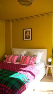 a bedroom with a bed with colorful blankets and pillows at Saint Michel - Centre Ville - Espace Coty in Le Havre