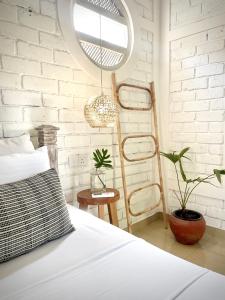 um quarto com uma cama e uma parede de tijolos brancos em The Yard Hiriketiya em Hiriketiya