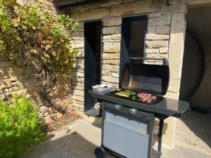 a barbecue grill in front of a stone building at Coeur de Pommard in Pommard