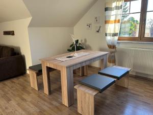 Habitación con mesa de madera y 2 taburetes en Ferienwohnung Rhön Verliebt, en Abtsroda