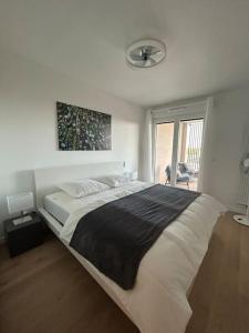 een slaapkamer met een groot bed en een raam bij Magnifique appartement T4 in Bordeaux
