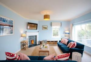 a living room with a blue couch and a fireplace at Home near Port Isaac sleeps 10 in Port Isaac