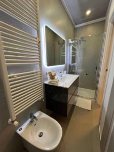 La salle de bains est pourvue d'un lavabo, de toilettes et d'un miroir. dans l'établissement Appartamento Melissa, à Porto SantʼElpidio