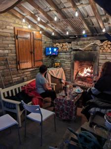 a group of people sitting in a room with a fireplace at Charming 1-Bed Cottage on the outskirts of Haworth in Keighley
