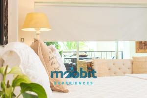 um quarto com uma cama branca e um candeeiro em Hermoso y perfecto 2 Hab frente al mar en Cap Cana em Punta Cana