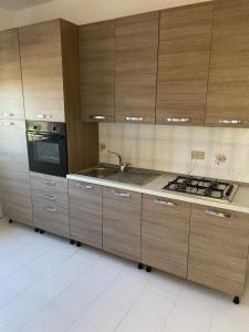 a kitchen with wooden cabinets and a sink and a stove at limoneto in Trabia