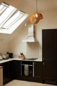a kitchen with black cabinets and a white stove top oven at The Old Winery Cottage No2 in Shepton Mallet