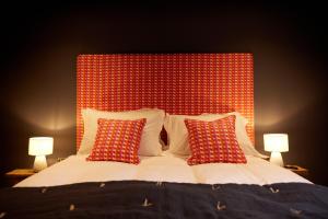 a bed with a red head board with two lamps at The Old Winery Cottage No2 in Shepton Mallet