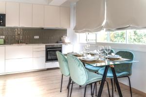 een keuken met een eettafel met groene stoelen bij Soler Apartments in Sant Adria de Besos