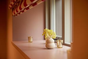 un jarrón con flores sentado en un mostrador con una ventana en The Old Winery Cottage No2, en Shepton Mallet