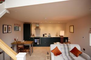 a living room and kitchen with a couch and a table at The Old Winery Cottage No1 in Shepton Mallet