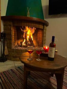 dos copas de vino en una mesa con chimenea en Diminio 2 Whole House - Chalet, en Arachova