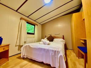 1 dormitorio con 1 cama grande con sábanas blancas en The Raddle Inn Log Cabins, en Croxden