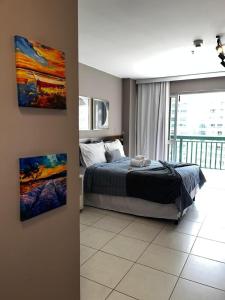 1 dormitorio con 1 cama y una pintura en la pared en Flat Luxo Fusion SHN - Melhor Localização de BSB, en Brasilia