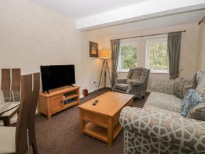 a living room with a couch and a tv at Apartment 4 in Keswick