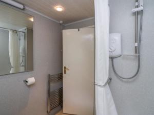 a bathroom with a shower and a toilet and a mirror at Apartment 4 in Keswick +46 photos