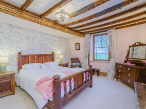 a bedroom with a large bed and a tv in it at The Druids in Corwen