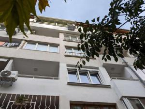 a white building with windows and a balcony at Lazur Apartment in Burgas