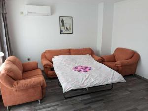 a living room with a couch and two chairs at Lazur Apartment in Burgas