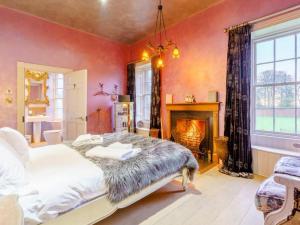 a bedroom with a large bed and a fireplace at The Garden Rooms in Fettercairn