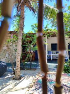 a view through the fence of a resort with palm trees at Hospedaria Arte Sagrada in Canguaretama