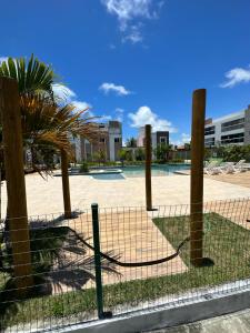 a fence with a palm tree and a volley ball court at casamarfrances in Praia do Frances