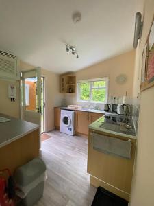una cucina con lavandino e piano cottura di Baillie Chalet on Reelig Estate Near Inverness a Kirkhill